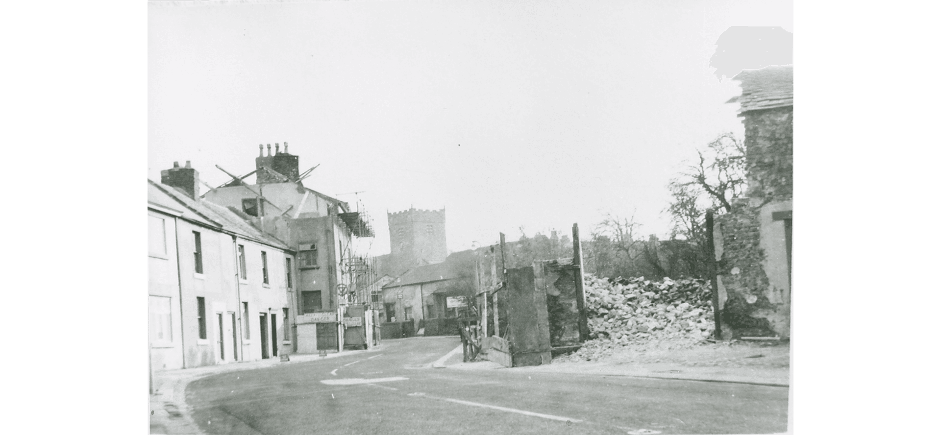 Tithebarn Street, looking south east with the church in the background. The demolished tithebarn and house to the right. A terrace of old houses to the left.