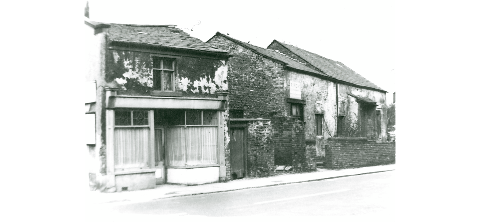 Here we see the Tithebarn and the adjacent shop with bow window. The Tithebarn is fully intact but in a state of poor repair.